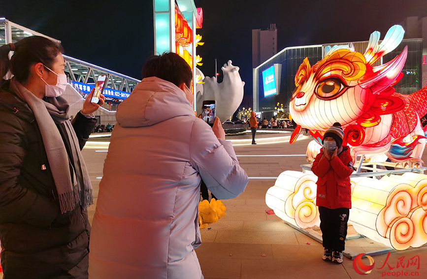 2023年12月31日，天津市民在西青大悦汇龙形灯饰前拍照留念。人民网记者 陶建摄