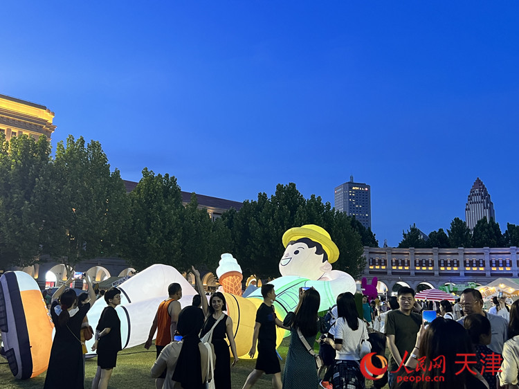 在五大道民园广场，游客们与人偶合影。人民网记者 孙翼飞摄