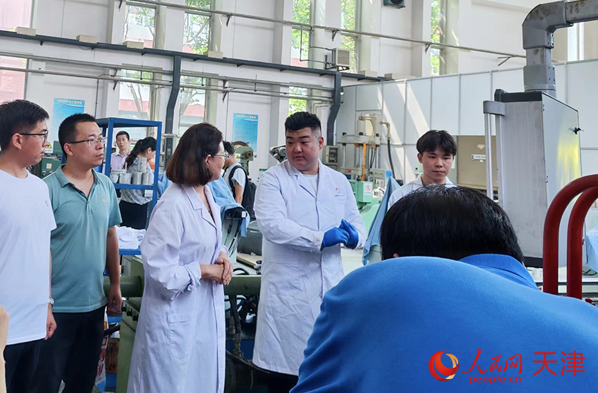 实验室内，陈民芳教授（左三）正在指导学生操作设备。人民网 郭维瑾摄